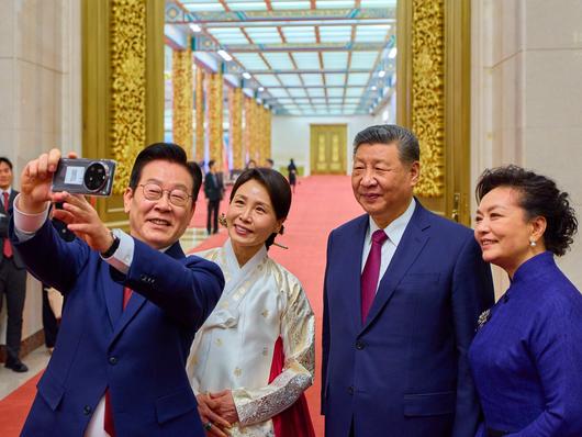 이재명 대통령 부부가 5일 베이징 인민대회당에서 열린 국빈만찬을 마친 뒤 시진핑 중국 국가주석 부부와 작년 11월 경주 정상회담 때 선물 받은 샤오미 스마트폰으로 기념촬영을 하고 있다. 왼쪽부터 이 대통령, 김혜경 여사, 시 주석, 평리위안 여사. /뉴스1