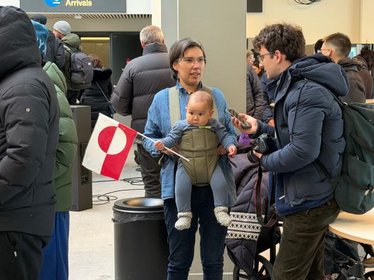한 그린란드 여성이 20일 누크 공항에서 취재진과 인터뷰하고 있다. 아기가 그린란드 깃발을 들고 있다./원선우 특파원