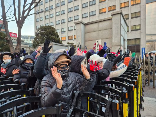22일 서울 성북경찰서 유치장에서 출발한 전광훈 사랑제일교회 목사가 서울서부지검에 도착하자 지지자 60여 명이 양손을 들어 전 목사에게 인사하고 있다./권우석 기자