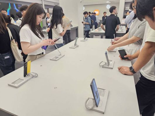 샤오미 스토어에서 샤오미 15 스마트폰을 체험하는 방문객들 / 출처=IT동아