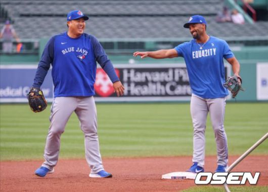 [사진]토론토의 류현진이 12일(한국시간) 펜웨이 파크에서 벌어지는 보스턴과의 원정 경기에 앞서 가진 수비훈련 도중 마커스 시미엔과 크게 웃고 있다.<토론토 블루제이스 공식 트위터 캡처>