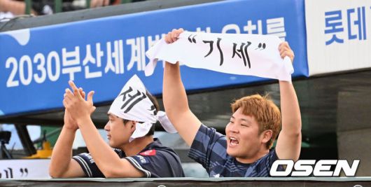 [OSEN=부산, 이석우 기자]롯데 자이언츠 나균안과 한현희가 ‘기세데이’를 맞아 팬들에게 나눠준 ‘기세’라고 씌여진 응원수건을 들고 반즈를 응원하고 있다. 2023.06.07 / foto0307@osen.co.kr