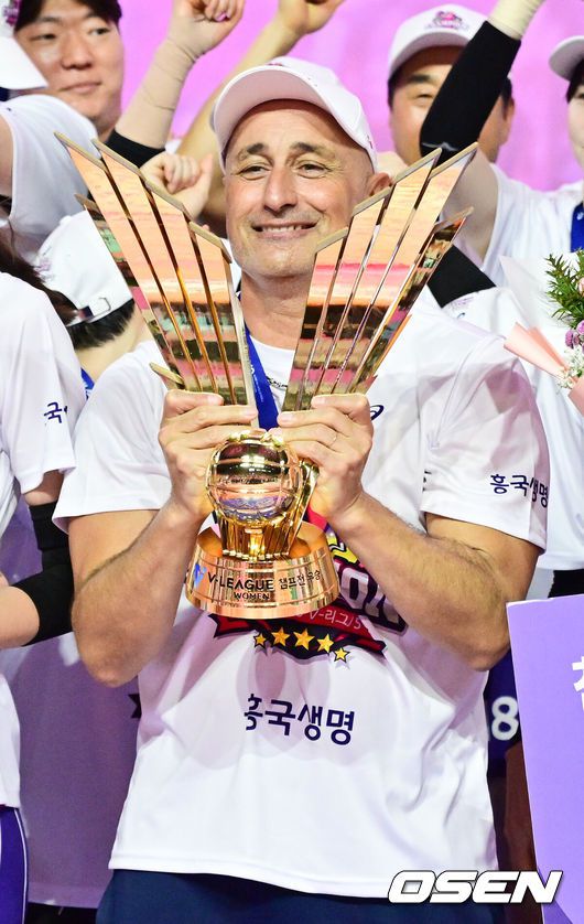 [OSEN=인천, 박준형 기자] 흥국생명 핑크스파이더스가 통산 5번째 챔피언결정전 우승을 차지했다. 김연경(37)은 현역 마지막 시즌을 통합우승으로 화려하게 장식했다.흥국생명은 8일 인천 삼산월드체육관에서 열린 ‘도드람 2024-2025 V-리그’ 챔피언결정전 5차전 정관장 레드스파크스와의 경기에서 세트스코어 3-2(26-24, 26-24, 24-26, 23-25, 15-13)승리를 거뒀다. 시리즈 전적 3승 2패로 마침내 5번째 우승에 성공했다.시상식 이후 흥국생명 아본단자 감독이 우승 트로피를 들고 포즈를 취하고 있다   2025.04.08 / soul1014@osen.co.kr