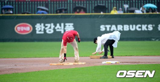 [OSEN=인천, 최규한 기자] 19일 오후 인천 SSG랜더스필드에서 ‘2025 신한 SOL Bank KBO리그’ SSG 랜더스와 LG 트윈스의 경기가 열렸다.이날 홈팀 SSG은 송영진, 방문팀 LG는 손주영을 선발로 내세웠다.4회초 1사 1, 2루 상황 LG 문성주 타석을 앞두고 우천으로 경기가 중단됐다. 젖은 내야를 정비하는 SSG 그라운드 관리 요원들. 2025.04.19 / dreamer@osen.co.kr