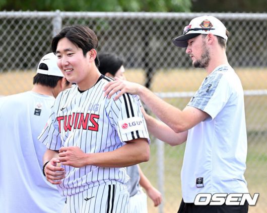 [OSEN=애리조나(미국), 이대선 기자] 15일(한국시간) 미국 애리조나주 스코츠데일 인디언스쿨 파크 베이스볼필드에서 LG 트윈스의 1차 스프링캠프가 진행됐다. LG 캠프 초청선수 코엔 윈이 손주영의 어깨를 주무르고 있다. 2025.02.15 / sunday@osen.co.kr