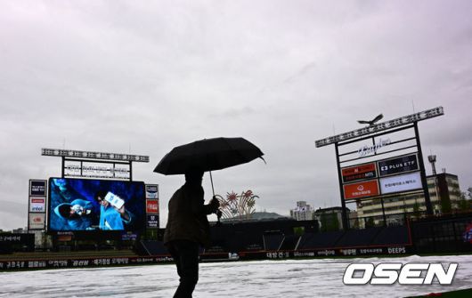 [OSEN=대전, 지형준 기자] 1일 대전 한화생명볼파크에서 2025 신한 SOL Bank KBO리그 한화 이글스와 LG 트윈스의 경기가 열린다.이날 한화는 엄상백, LG는 손주영이 선발로 나선다.이날 비 예보가 있는 가운데 한화생명볼파크에 비가 내리고 있다. 김시진 경기감독관이 그라운드를 살피고 있다. 2025.05.01 /jpnews@osen.co.kr