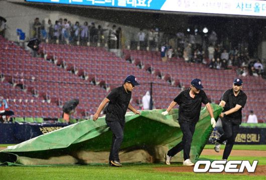 [OSEN=잠실, 지형준 기자] 23일 오후 서울 잠실구장에서 2025 신한 SOL Bank KBO리그 두산 베어스와 NC 다이노스의 경기가 열렸다.이날 두산은 콜어빈, NC는 로건 앨런을 선발로 내세웠다.연장 10회 초를 앞두고 계속되는 비에 마운드에 방수포를 깔며 경기가 중단되고 있다. 025.05.23 /jpnews@osen.co.kr