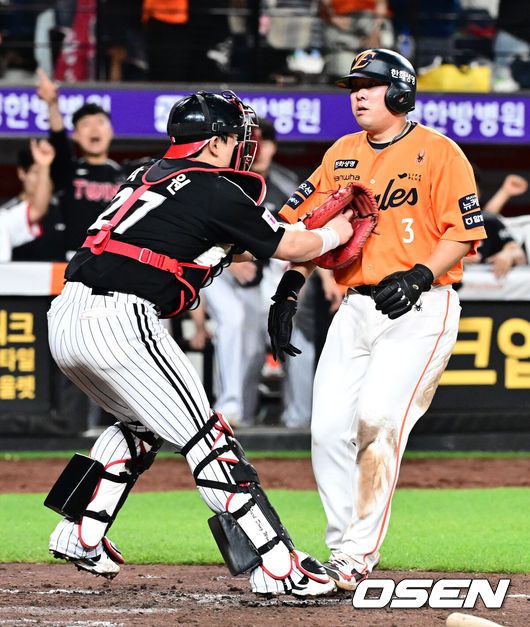 [OSEN=대전, 지형준 기자] 프로야구 한화 이글스와 LG 트윈스가 연장 11회 접전을 펼쳤으나 승부를 가리지 못했다.한화와 LG는14일 대전 한화생명볼파크에서 열린 2025 KBO리그 정규 시즌 맞대결 9차전에서 연장 11회 2-2 무승부를 기록했다.LG는 1위를 지켰고, 한화는 LG와 0.5경기 차이를 유지했다. 연장 11회말 2사 2루에서 한화 안치홍이 이재원의 좌전 안타에 홈에서 LG 박동원에 태그아웃 당하고 있다. 2025.06.14 /jpnews@osen.co.kr