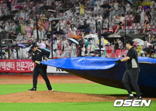 [OSEN=수원, 김성락 기자] 24일 오후 수원 KT위즈파크에서 2025 신한 SOL Bank KBO리그 KT 위즈와 LG 트윈스의 경기가 열렸다.KT는 헤이수스, LG는 치리노스를 선발투수로 내세웠다.6회초 종료 후 쏟아지는 강우에 경기 관계자가 마운드에 방수포를 깔고 있다. 2025.06.24 / ksl0919@osen.co.kr