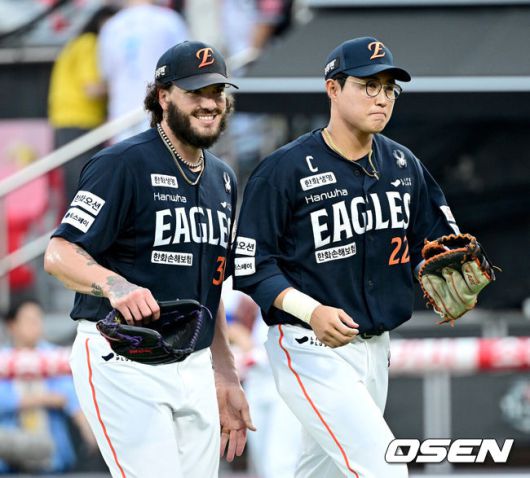 [OSEN=수원, 최규한 기자] 18일 수원 KT위즈파크에서 ‘2025 신한 SOL Bank KBO리그’ KT 위즈와 한화 이글스의 경기가 열렸다.홈팀 KT는 오원석, 방문팀 한화는 코디 폰세를 선발로 내세웠다.1회말 KT 공격을 실점없이 막아낸 한화 선발 코디 폰세가 더그아웃으로 향하며 1루수 채은성과 미소짓고 있다. 2025.07.18 / dreamer@osen.co.kr