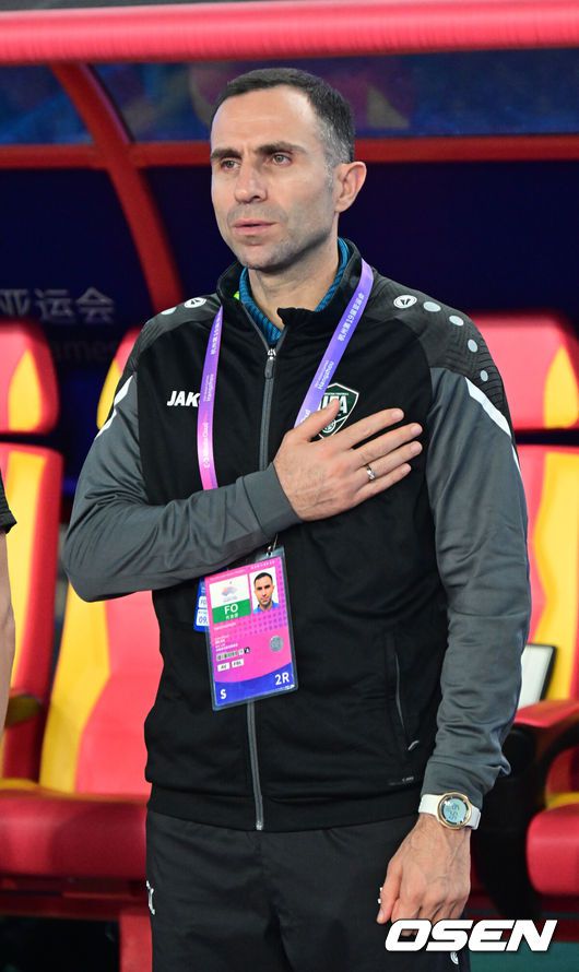 [OSEN=항저우(중국), 최규한 기자] 4일 오후 중국 항저우 황룽 스포츠센터 스타디움에서 ‘2022 항저우 아시안게임’ 남자축구 4강 대한민국과 우즈베키스탄의 경기가 열렸다.경기 시작을 앞두고 우즈벡 티무르 카파제 감독이 국기에 대한 경례를 하고 있다. 2023.10.04 / dreamer@osen.co.kr