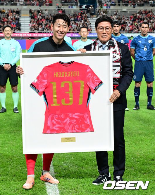 [OSEN=서울월드컵경기장, 조은정 기자]홍명보 감독이 이끄는 대한민국 대표팀과 파라과이의 A매치 평가전이 14일 오후 서울월드컵경기장에서 열렸다.'남미 강호' 파라과이는 지난 10일 일본 원정에서 2-2 무승부를 거두고 온 팀이다. 이번 경기는 홍명보호의 2026 북중미 월드컵 포트 배정을 두고도 중요한 일전이다.현재 한국은 오스트리아, 호주, 에콰도르와 치열한포트 2 막차 경쟁을 벌이고 있다.경기 전 차범근 전 감독이 경기장을 찾아 손흥민에게 기념 유니폼을 직접 전달하고 있다. 2025.10.14 /cej@osen.co.kr