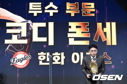 [OSEN=조은정 기자] 9일 오후 서울 송파구 잠실동 롯데호텔 월드에서 2025 신한은행 SOL 뱅크 KBO 골든글러브 시상식이 열렸다.KBO 골든글러브 시상식은 포지션별 최고의 선수를 가리는 자리로 올 시즌의 대미를 장식하는 자리다.한화 손혁 단장이 투수 부문 수상한 한화 코디 폰세 대리 수상을 하고 있다. 2025.12.09 /cej@osen.co.kr