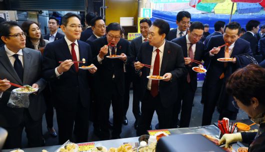 윤석열 대통령과 이재용 삼성전자 회장 등 참석자들이 6일 부산 중구 깡통시장을 방문해 떡볶이를 시식하고 있다. 대통령실사진기자단