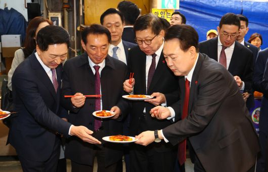 윤석열 대통령이 6일 부산 중구 깡통시장을 방문해 떡볶이를 동행한 이들에게 나눠주고 있다. 대통령실사진기자단