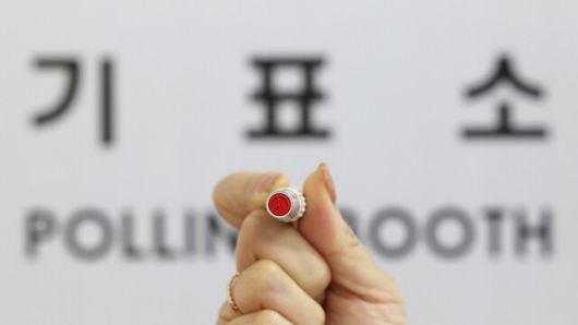 제22대 국회의원 선거 사전투표를 하루 앞둔 4일 오후 서울 강남구 삼성2동 사전투표소에서 선거사무원이 기표소 앞에서 기표용구를 들어 보이고 있다. 연합뉴스