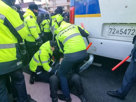 윤석열 대통령 지지자가 경찰 버스 아래로 들어가려 하고 있다. 고나린 기자