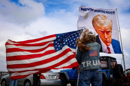 2024년 12월 14일, 미국 대통령 당선인 도널드 트럼프의 별장이 있는 플로리다주 마러라고 리조트 근처에서 트럼프 지지자들이 미국 국기와 트럼프 사진 깃발을 흔들고 있다. AFP 연합뉴스
