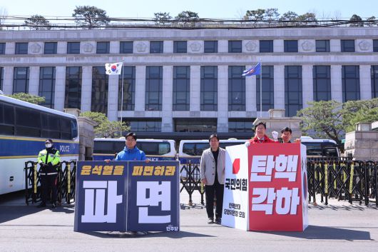 헌법재판소가 윤석열 대통령 탄핵심판 선고를 앞두고 논의를 이어가고 있는 28일 서울 종로구 헌재 앞에서 여야 의원들이 탄핵 찬반 1인 시위를 벌이고 있다. 연합뉴스