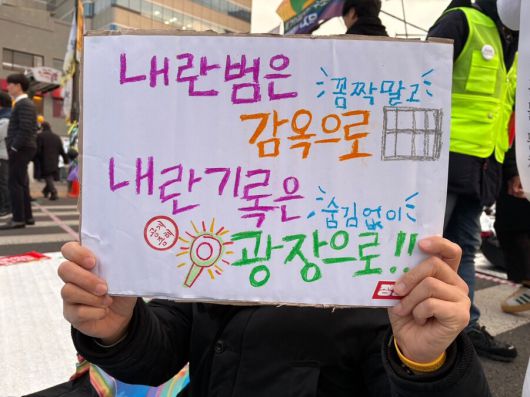 2일 저녁 윤석열 즉각퇴진·사회대개혁 비상행동이 연 내란수괴 윤석열 즉각파면 집회 참가자가 직접 만든 손팻말을 들고 있다. 임재희 기자