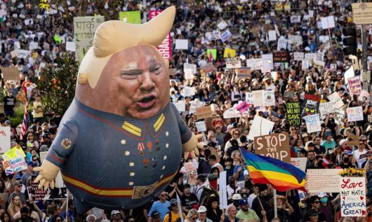 5일 미국 로스앤젤레스에서 도널드 트럼프 대통령을 비판하는 시민들이 그를 풍자한 풍선과 함께 행진하고 있다. 로스앤젤레스/AFP 연합뉴스