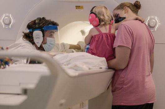 연구진이 아기를 위해 특별히 제작한 뇌 영상 장치로 실험을 하고 있다. 예일대 제공