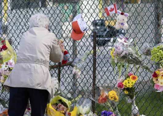 캐나다 밴쿠버 차량 돌진 사망 사고가 발생한 다음날인 27일, 사고 장소 근처에 꾸려진 추모 공간에 한 시민이 찾아와 추모 물품을 놓고 기리고 있다. AFP연합뉴스