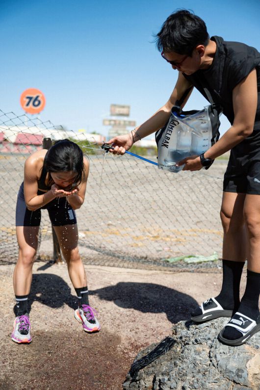 트레일러닝 크루 ‘꼬뮨 드 서울’의 조소영씨(왼쪽)가 지난 3월 말 미국 로스앤젤레스, 라스베이거스 등지에서 열린 비공식 장거리 달리기 대회 ‘더 스피드 프로젝트’에서 달리던 중 물을 마시고 있다. 블룸스튜디오 제공