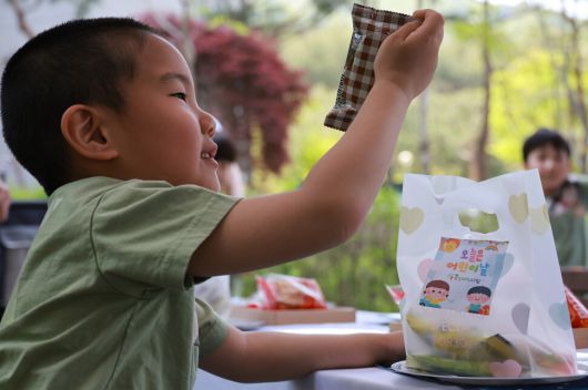지난달 30일 오전 어린이날을 앞두고 경기 남양주시 시립효성솔빛길어린이집 풋살장에서 하나어린이집과 효성솔빛길어린이집이 함께 연 ‘소소한 소풍’에서 하나어린이집 성재가 어린이날 선물을 받고 좋아하고 있다. 김혜윤 기자 unique@hani.co.kr