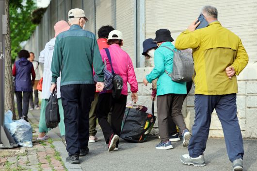 금호타이어 광주공장 화재가 발생한 17일 오후 광주 광산구 소촌동 한 아파트 인근 도로에서 주민들이 대피소로 가는 버스에 타기 위해 이동하고 있다. 광주시와 광산구는 화재로 발생하는 검은 연기의 직접적인 영향을 받는 인접 4개 아파트 단지 주민들을 위해 광주여자대학교 체육관에 대피소를 마련했다. 연합뉴스