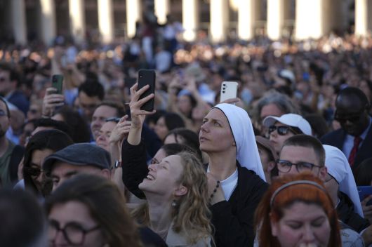지난 8일(현지시각) 바티칸 시스티나 경당(성당)의 굴뚝에서 새 교황이 선출됐음을 알리는 흰 연기가 피어오르자 신자와 시민들이 환호하며 사진을 찍고 있다. AP 연합뉴스