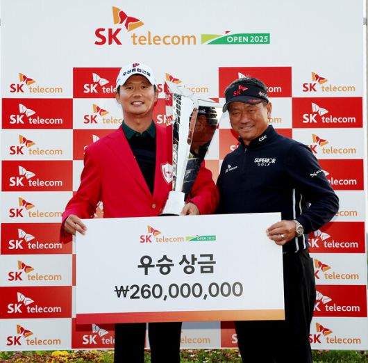 최경주가 18일 제주 서귀포 핀크스 골프클럽에서 열린 한국프로골프 투어 SK텔레콤 오픈 시상식에서 엄재웅에게 우승 트로피와 상금을 전달하고 있다. KPGA 제공