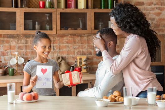 아버지의 날을 맞아 딸이 아버지에게 깜짝 선물을 하며 기뻐하고 있다. 게티이미지뱅크