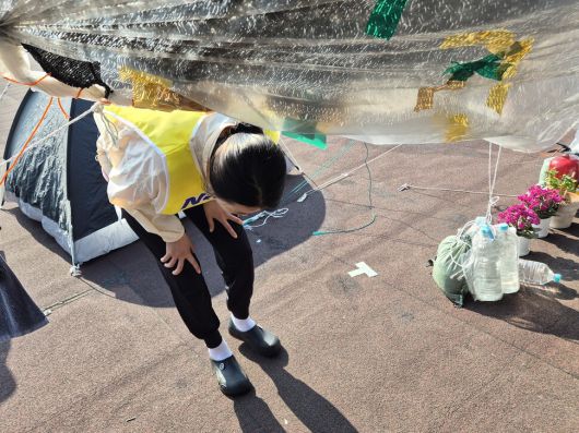 고공농성 500일을 열흘 앞둔 2025년 5월11일, 박정혜씨가 취재진을 안내하러 텐트 안으로 들어서고 있다. 천막이 낮아 늘 허리를 굽혀야 해, 허리 통증이 심하다. 신다은 기자