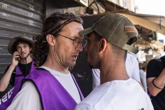 26일(현지시각) 예루살렘 구시가지에서 시위에 참여 중인 이스라엘 우익 청년과 폭력 시위를 방어하기 위해 자원봉사 중인 보라색 조끼를 입은 반전 단체 활동가가 대립하고 있다. 예루살렘/AFP 연합뉴스