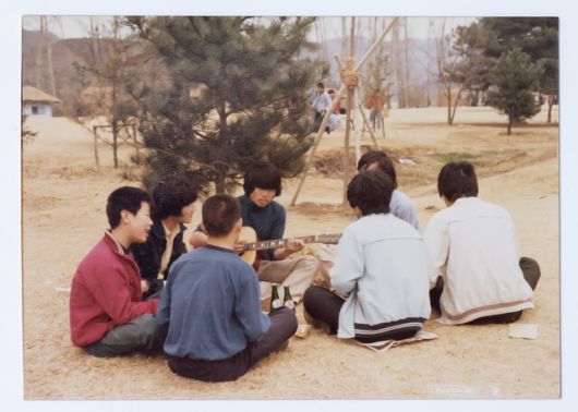 1979년 이재명 대통령 당선자(왼쪽 첫째)가 시계 만드는 오리엔트 공장에 다닐 때 남이섬으로 야유회를 가 둥글게 앉아 노래하는 모습. 더불어민주당 제공