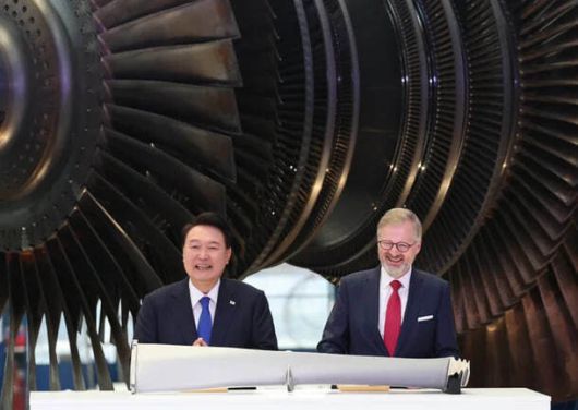 윤석열 전 대통령이 지난해 9월 체코 플젠 산업단지 내 두산스코다파워 공장에서 페트로 피알라 체코 총리와 함께 터빈 블레이드에 서명한 뒤 밝게 웃고 있다. 연합뉴스