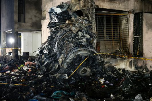 12일(현지시각) 인도 서부 아메다바드 사르다르 발라브바이 파텔 국제공항 인근 건물에 에어인디아 여객기 잔해가 있다. 아메다바드/로이터 연합뉴스