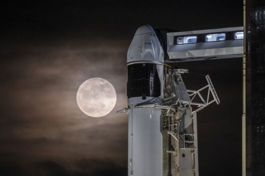 몸을 낮춘 보름달이 스페이스엑스의 팰컨9 로켓과 우주선을 훔쳐보듯 지나가고 있다. 스페이스엑스 제공