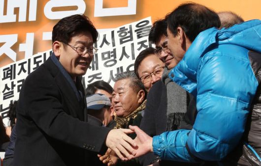 이재명 대통령이 첫 번째 대선에 도전한 2017년 1월23일 과거 ‘소년공’으로 일했던 경기 성남시 오리엔트 시계 공장 마당에서 대선 출마 선언을 한 뒤, 자신과 함께 시계공장에서 일했던 동료들을 무대 위로 올라오게 해 인사를 나누고 있다. 한겨레 자료사진