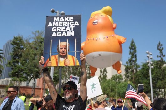 도널드 트럼프 미국 대통령의 79번째 생일이자 미 육군 창설 250주년 기념 열병식이 열린 14일(현지시각) 캘리포니아 로스앤젤레스에서 열린 ‘노 킹스’ 집회에서 참석자들이 손팻말을 들고 있다. 로스앤젤레스/로이터 연합뉴스