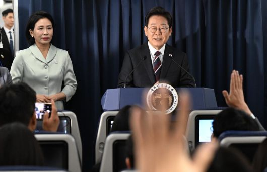 이재명 대통령이 16일 주요 7개국(G7) 정상회의 참석을 위해 캐나다 앨버타주 캘거리로 향하는 공군 1호기 기내에서 기자회견을 하는 가운데 김혜경 여사가 옆을 지키고 있다. 캘거리/김태형 기자 xogud555@hani.co.kr