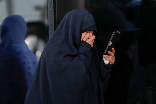 17일 이라크 카르발라에서 한 여성이 전화로 이란에 있는 친척이 이스라엘의 공습으로 사망했다는 소식을 접한 뒤 눈물을 흘리고 있다. 카르발라/AFP연합뉴스