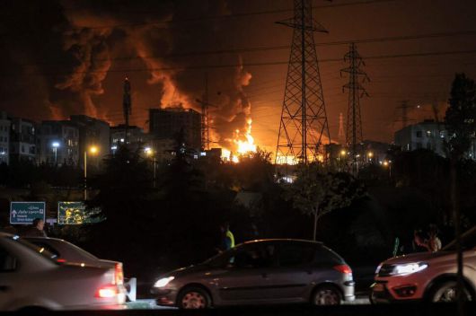 15일, 테헤란 북서부 석유 저장고 인근에서 화재가 발생한 가운데, 차량들이 고속도로 위에서 정체되어 있다. AFP 연합뉴스