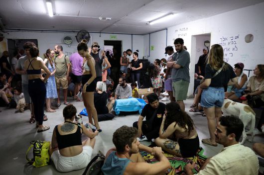 18일(현지시각) 이스라엘 텔아비브에서 사람들이 이란의 미사일 공습을 피해 방공호에서 대피하고 있다. 텔아비브/로이터 연합뉴스