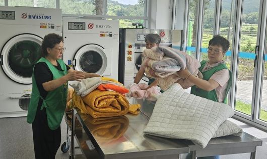 지난 19일 전남 완도군 청산면 마을 공동 빨래방에서 주민들이 세탁물을 정리하고 있다. 전남도 제공
