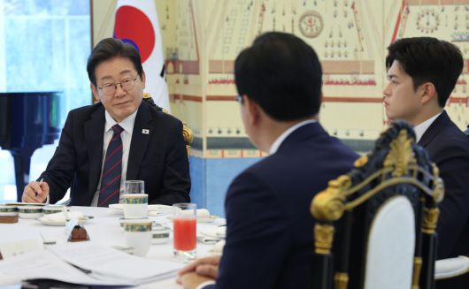 이재명 대통령이 22일 서울 용산구 한남동 관저에서 열린 여야 지도부와의 오찬에서 국민의힘 송언석 원내대표(뒷모습)의 발언을 듣고 있다. 맨 오른쪽은 김용태 국민의힘 비대위원장. 대통령실사진기자단
