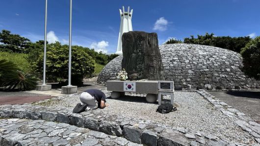 일본 오키나와 남부 이토만시 오키나와 평화기념공원의 한국인위령탑 앞에서 한 한국인 청년이 절을 하고 있다.