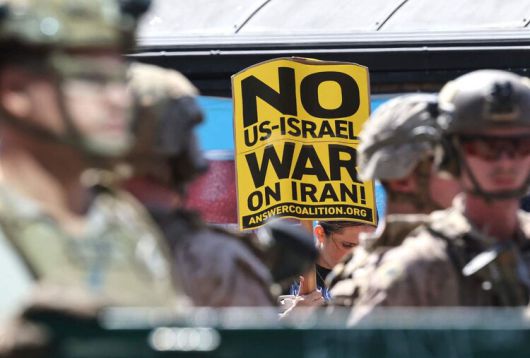 22일(현지시각) 미국의 이란 공습을 반대하는 시민들이 미국 캘리포니아 로스앤젤레스에 있는 윌셔 연방청사 앞에 모여 ‘이란에서 전쟁 반대’ 손팻말을 들고 시위를 하고 있다. 로스앤젤레스/AFP 연합뉴스