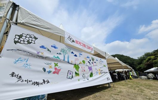 27일 오전 ‘산내골령골학살희생자 합동위령제’가 진행된 대전 동구 낭월동 골령골에 전날 이곳에서 열린 ‘골령골 평화예술제’에 참여한 시민들이 함께 걸게그림이 전시돼 있다. 최예린 기자
